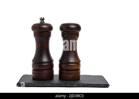 Pepper shaker and salt shaker on slate stone on white background Stock Photo