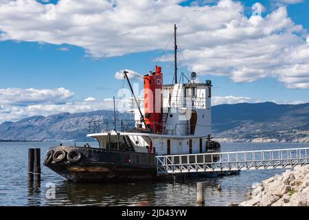 Tugboats British Columbia. The tug boat moored in Okanagan Lake with mountains and blue sky in the background-June 6,2022-Penticton Canada-Travel phot Stock Photo