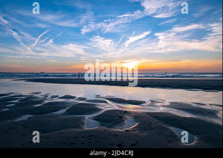 Sunset in the North Sea with natural water-sand pattern in the foreground Stock Photo
