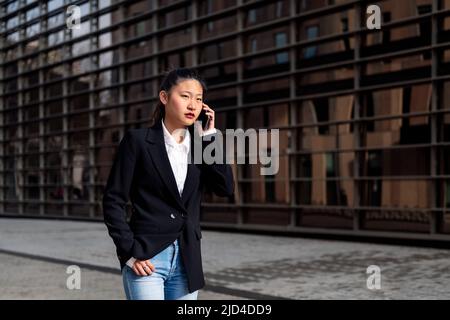 serious asiatic businesswoman talking on the phone Stock Photo