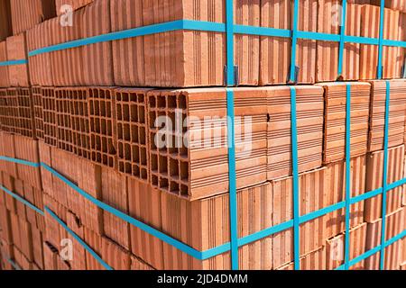 Pallets with freshly made racks of bricks at a construction site or near an industrial plant. Storage of building materials at the warehouse Stock Photo