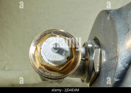 Stuttgart, Germany - February 01, 2022: Install Heimeier thermostatic valve. Open-end wrench screws component to the old radiator. Modernize heating s Stock Photo