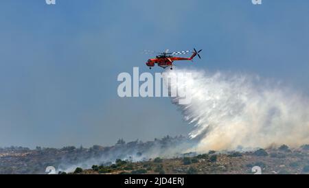 Athens, Greece, June 4, 2022: A firefighting Erickson S-64 Aircrane helicopter operates in Hymettus mount wildfire near Glyfada suburb of Athens. Stock Photo