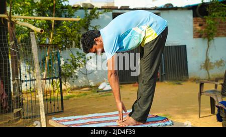 Young man doing yoga outdoors with amazing background. Stock Photo