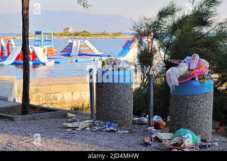 overspilled trash can on the beach Stock Photo