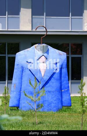 Statue of suit top with blue jacket, shirt and tie at garden of designing faculty in a sunny day Stock Photo