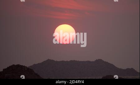 Spectacular sunset in Namibia Damaraland with mountain range in the background. Namibia Travel Destination. Seen at game drive. Stock Photo