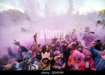 Festival goers throw colored powder at the main stage at Belladrum Tartan Hearts Festival at Inverness, United Kingdom Stock Photo