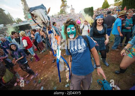 Festival goers throw colored powder at the main stage at Belladrum Tartan Hearts Festival at Inverness, United Kingdom Stock Photo