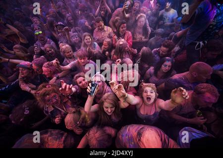 Festival goers throw colored powder at the main stage at Belladrum Tartan Hearts Festival at Inverness, United Kingdom Stock Photo