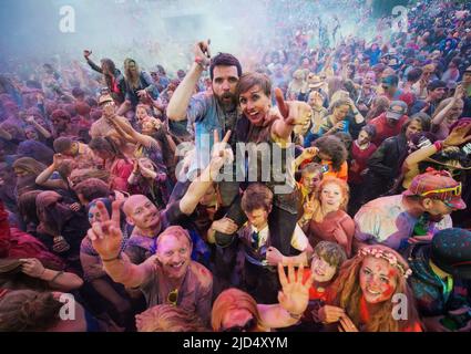 Festival goers throw colored powder at the main stage at Belladrum Tartan Hearts Festival at Inverness, United Kingdom Stock Photo