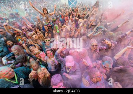 Festival goers throw colored powder at the main stage at Belladrum Tartan Hearts Festival at Inverness, United Kingdom Stock Photo