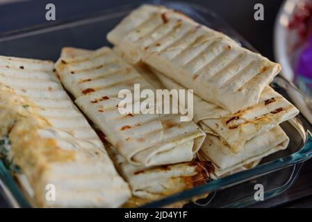 doner kebab, shawarma in pit of fresh vegetables and meat. Shawarma sandwich gyro fresh roll of lavash pita bread filled with grilled meat, mushrooms, cheese. Traditional Middle Eastern snack Stock Photo