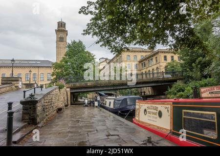 Boats on the Leeds And Liverpool Canal at Salts Mill, Saltaire, a Victorian model village, Shipley, Bradford, West Yorkshire, England. Stock Photo