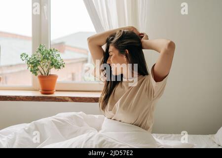 A young European woman waking up in the morning stretches and enjoys