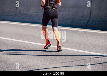 male athlete in compression socks running marathon Stock Photo