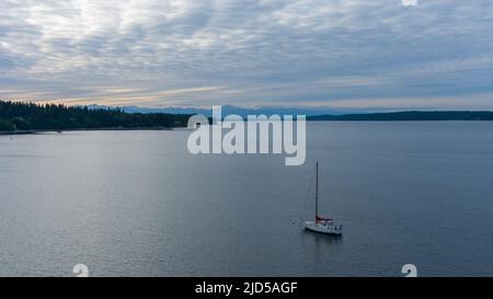 Lone sailboat on the Puget Sound at Nisqually Reach in Washington state Stock Photo