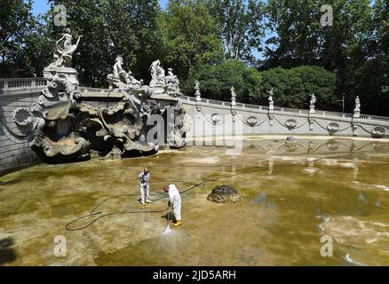 Turin, Italy. 18th June, 2022. People clean a fountain in Turin, Italy, June 18, 2022. A heatwave swept across Italy this week, sparking emergencies in at least four cities and putting half of the agricultural production in the north at drought risk. Credit: Str/Xinhua/Alamy Live News Stock Photo