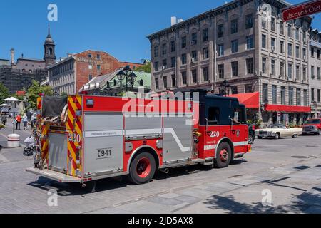 Montreal, CA - 11 June 2022: Red firetruck driving on De la Commune street in Old Montreal Stock Photo