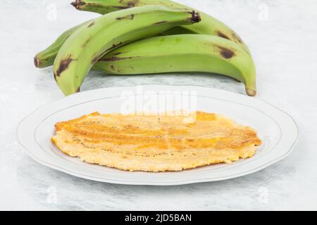 Patacon or toston fried and flattened pieces of green plantain, traditional snack or accompaniment in the Caribbean. Stock Photo