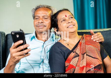 Relaxed senior couple enjoys listening music at home - concept of family bonding, entertainment and happiness Stock Photo