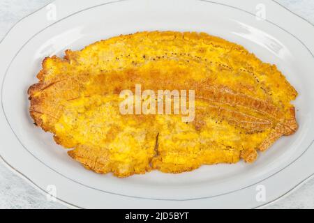 Patacon or toston fried and flattened pieces of green plantain, traditional snack or accompaniment in the Caribbean. Stock Photo