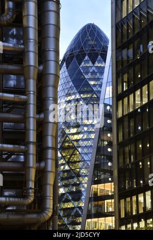 30 St Mary Axe (Gherkin), Willis Building and Lloyds building, modern landmark skyscrapers at dusk, City of London UK. Stock Photo