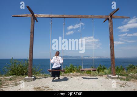 Woman on a swing on summer day Stock Photo
