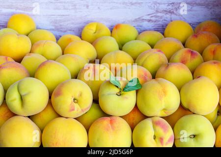 Many yellow peaches with appetizing appearance placed in a container box Stock Photo