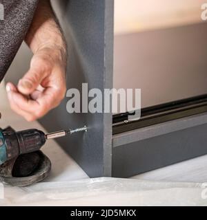 Fastening to a case of sliding accessories for doors of a sliding wardrobe, tools for installation of a case, installation works. Stock Photo