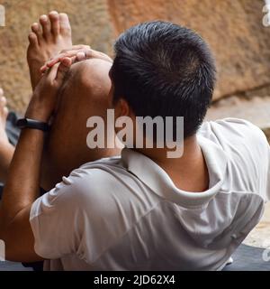 Inspired Indian young man doing yoga asanas in Lodhi Garden Park, New Delhi, India. Young citizen exercising outside and standing in yoga side angle p Stock Photo