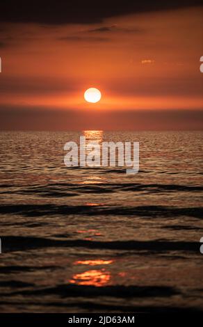 Sun setting over the sea Stock Photo
