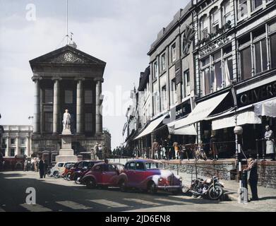 Market Jew Street, Penzance, Cornwall, England. The building with Ionic columns is the Market House, with the statue of Sir Humphry Davy, born in Penzance, in front. Colourised version of : 10154727       Date: early 1950s Stock Photo