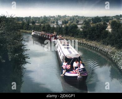 Holiday making by canal! A pair of converted narrow boats, with their cargo of happy holidaymakers, on the Grand Union Canal near Heyford Wharf, Northamptonshire. Colourised version of : 10181904       Date: 1960s Stock Photo