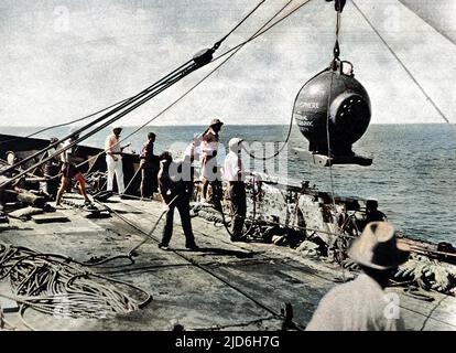 Photograph of Dr. William Beebe's bathysphere being lowered into the sea off St. George, Bermuda, 11th August 1934. On this occasion Dr. William Beebe and his photographer, Otis Barton, descended 2510 feet below sea level in their two-ton iron bathysphere. Colourised version of: 10216350       Date: 1934 Stock Photo