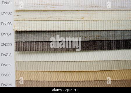 Samples of fabrics of different textures and colors in the form of a catalog for the selection of fabrics for fabric blinds. Samples of blinds day and Stock Photo
