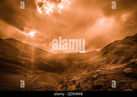 Fantasy color effect of bright sunlight shining through hole of clouds Stock Photo