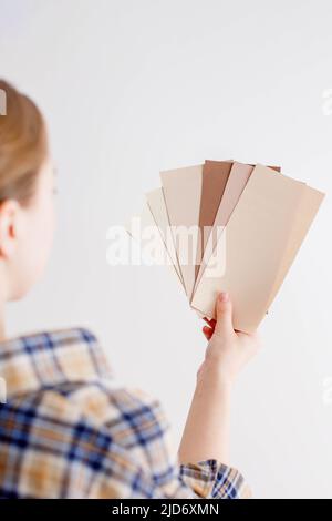 Young woman holds in her hand color paint samples for the wall Stock Photo