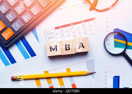 Concept MBA or master of business administration. Business acronym. Text on cubes and reporting charts Stock Photo