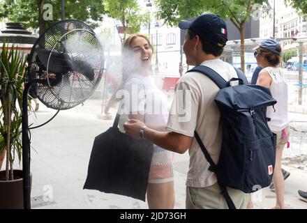 Madrid, Spain. 18th June, 2022. People enjoy a misting fan during a heatwave in Madrid, Spain, on June 18, 2022. Credit: Gustavo Valiente/Xinhua/Alamy Live News Stock Photo