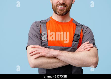 Unrecognizable smiling workerman in uniform with crossed hands looking at camera Stock Photo