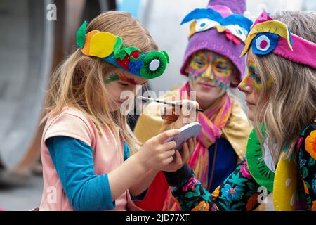 Seattle, Washington, USA. 18th June, 2022. Gina paints the face of her daughter Juniper as they prepare for the Fremont Solstice Parade to begin. The iconic, annual parade returned after a three-year hiatus due to the coronavirus pandemic. Credit: Paul Christian Gordon/Alamy Live News Stock Photo
