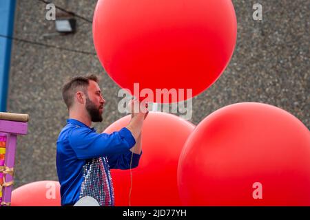 Seattle, Washington, USA. 18th June, 2022. Keith Neale inflates helium balloons for participants of the Fremont Solstice Parade. The iconic, annual parade returned after a three-year hiatus due to the coronavirus pandemic. Credit: Paul Christian Gordon/Alamy Live News Stock Photo