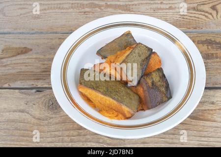 Close up shot of baked pumpkin in a plate with wooden background Stock Photo