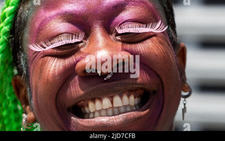 Coney Island, United States. 18th June, 2022. A woman smiles and shadows are cast on her cheeks from her eyelashes. The Coney Island Mermaid Parade is the largest Art Parade in the United States. The parade celebrates the start of summer. Revelers dress as mermaids, fish and other sea creatures. Credit: SOPA Images Limited/Alamy Live News Stock Photo