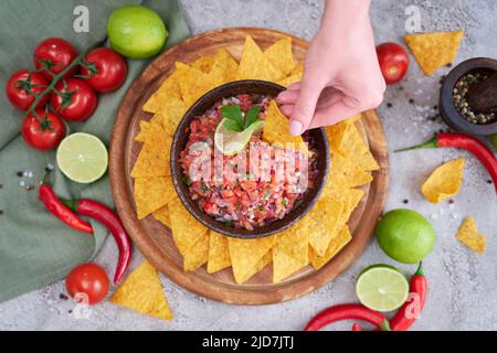freshly made salsa dip sauce with nacho chips on wooden board Stock Photo