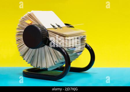 Rolodex file organizer sitting open on a colorful plain background with copy space. Stock Photo