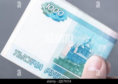 Hand with Russian rubles on a grey background, bills one thousand rubles Stock Photo