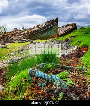 Salen, Isle of Mull, Scotland - Derelict wooden fishing boats abandoned on the beach which is slowly decaying and rotting Stock Photo