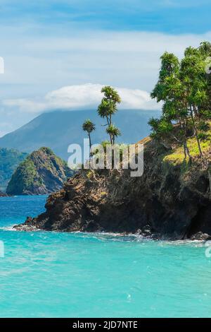 Beautiful turquoise sea at Mahoro Island with cloudy Karangetang volcano beyond. Mahoro, Siau Island, Sangihe Archipelago, North Sulawesi, Indonesia Stock Photo